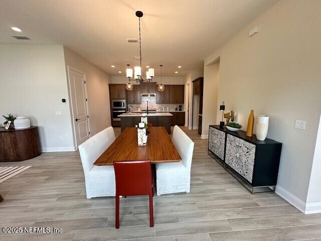 dining area featuring light wood finished floors, recessed lighting, and baseboards