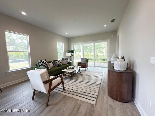 living room featuring recessed lighting, visible vents, baseboards, and light wood-style floors