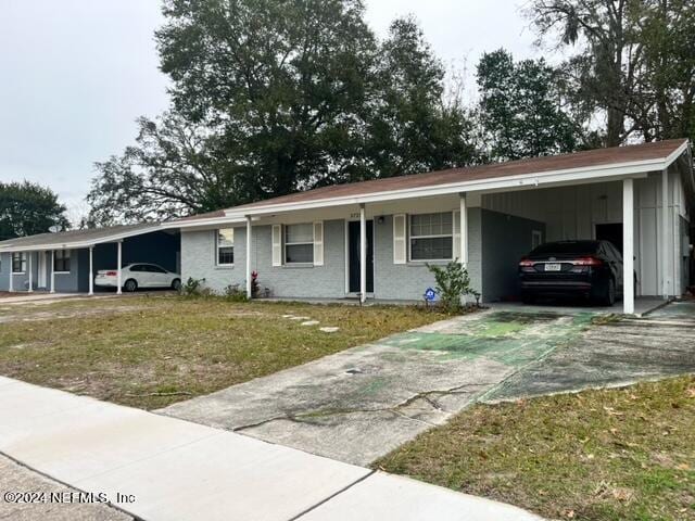 single story home with a front yard and a carport