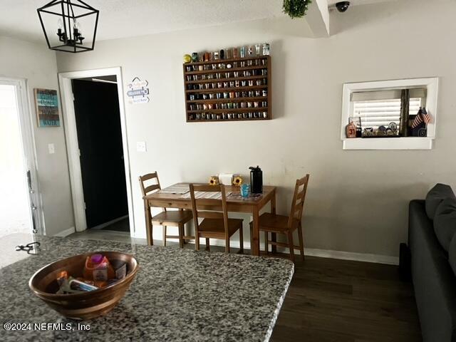 dining space with a notable chandelier and dark wood-type flooring