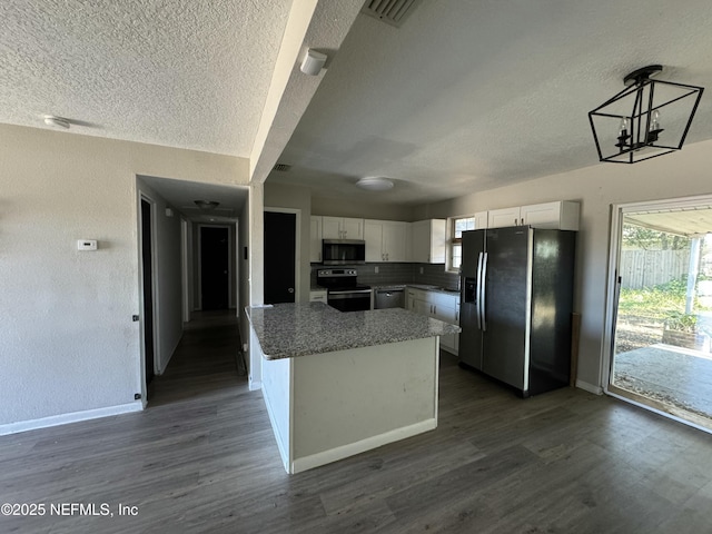 kitchen with stainless steel appliances, white cabinets, a chandelier, and decorative backsplash