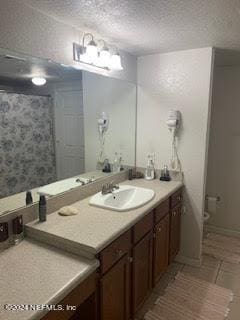 bathroom featuring vanity, a textured ceiling, and tile patterned flooring