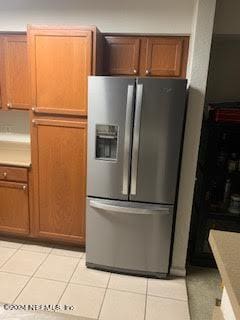 kitchen with light tile patterned floors and stainless steel fridge with ice dispenser