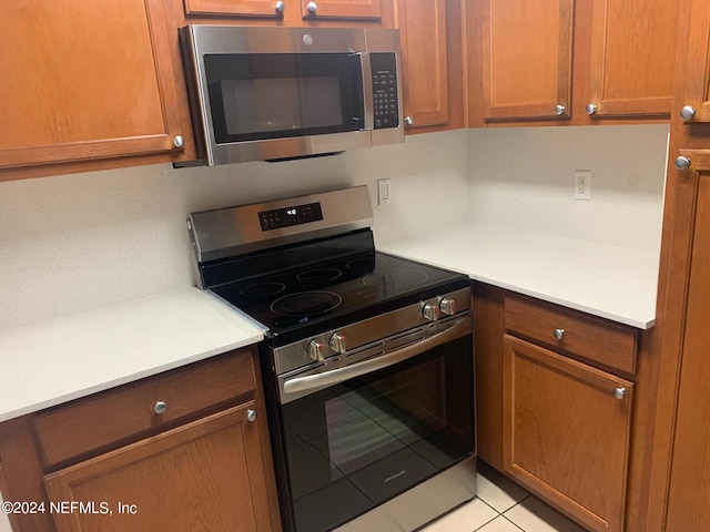 kitchen with light tile patterned flooring and appliances with stainless steel finishes