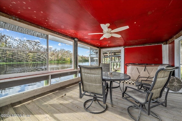 sunroom featuring a water view and ceiling fan