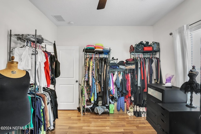 walk in closet with ceiling fan and hardwood / wood-style floors