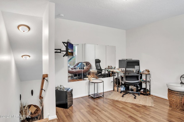 office featuring a textured ceiling and light hardwood / wood-style flooring