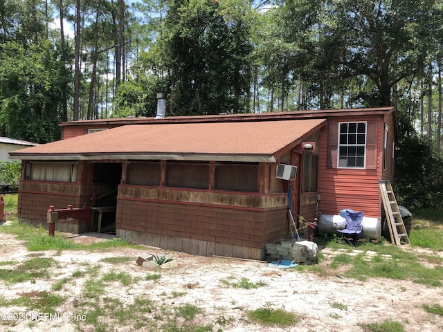 view of front of home featuring an AC wall unit