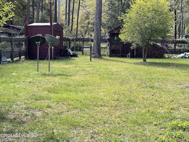 view of yard featuring a shed, an outbuilding, and fence