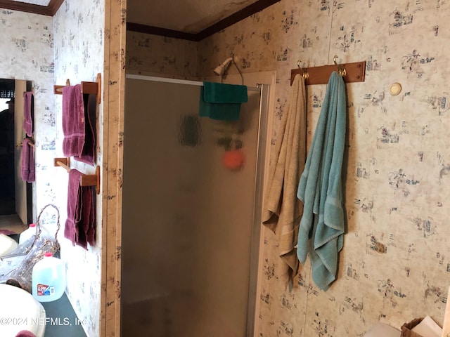 bathroom featuring a shower with door and ornamental molding