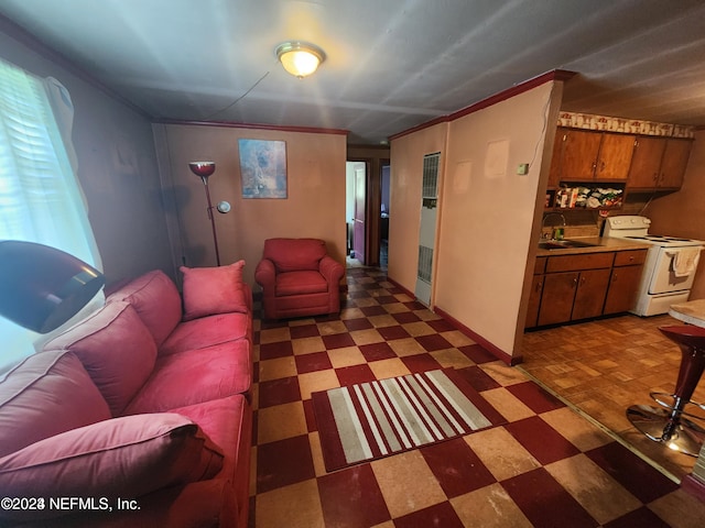 living room with crown molding, dark tile floors, and sink