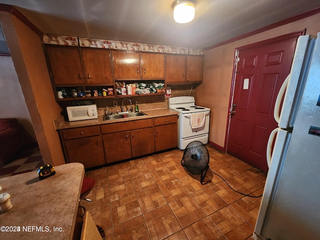 kitchen with light tile flooring, washer / dryer, sink, and fridge