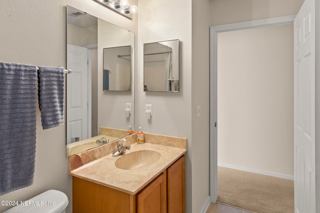 bathroom featuring vanity, tile flooring, and toilet