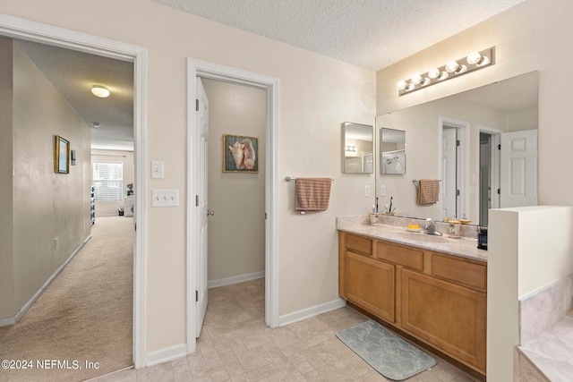 bathroom with a textured ceiling, tile floors, and oversized vanity