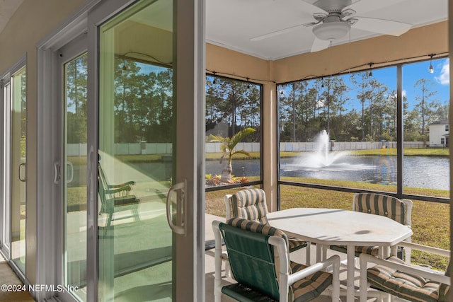 sunroom with a water view and ceiling fan