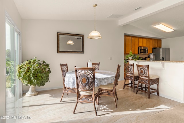 dining room with vaulted ceiling with beams and light tile flooring