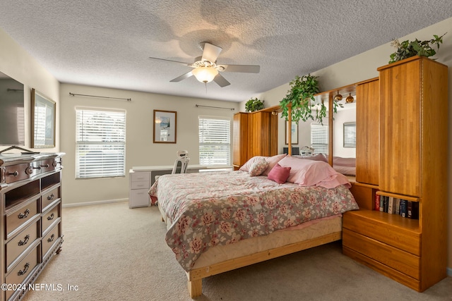 carpeted bedroom with a textured ceiling and ceiling fan