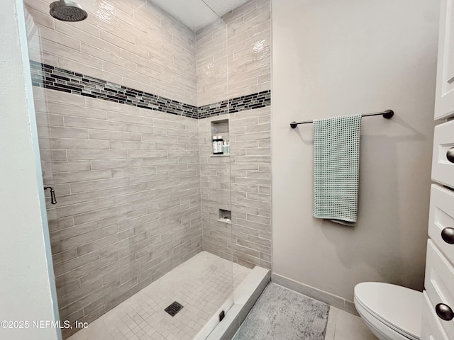 bathroom with tile patterned floors, tiled shower, and toilet