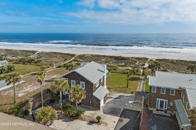 drone / aerial view featuring a beach view and a water view