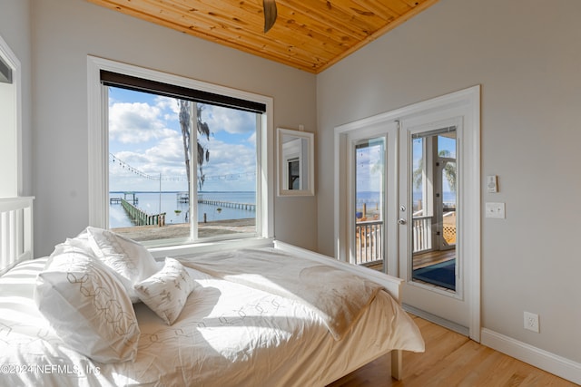 bedroom featuring wooden ceiling, multiple windows, and a water view