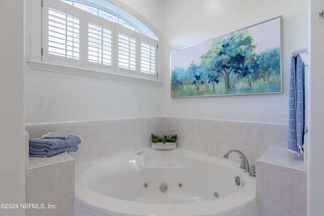 bathroom with a healthy amount of sunlight and tiled bath