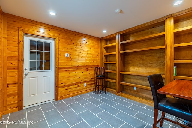 office space featuring wood walls and dark tile flooring