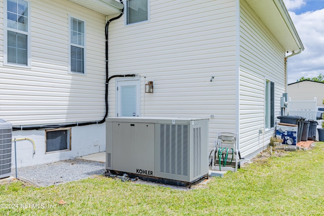 rear view of house with central AC unit and a yard