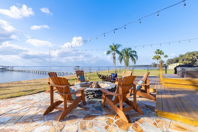 exterior space with a water view, a patio area, and an outdoor fire pit