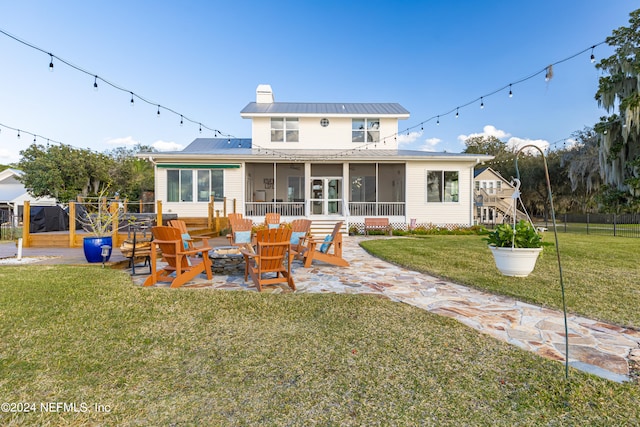 rear view of house featuring a patio area, a yard, and a sunroom