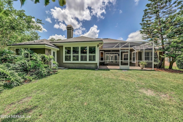 rear view of property with a patio area, a lanai, and a lawn