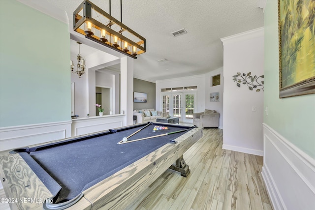 game room featuring french doors, crown molding, hardwood / wood-style floors, a textured ceiling, and pool table