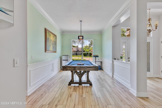 playroom featuring a textured ceiling, light wood-type flooring, crown molding, and billiards