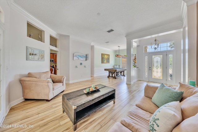 living room featuring built in shelves, a notable chandelier, billiards, light hardwood / wood-style floors, and a textured ceiling