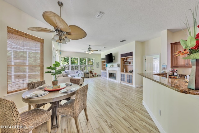 dining space featuring a textured ceiling, light hardwood / wood-style flooring, and ceiling fan