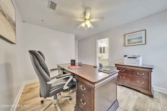 office featuring ceiling fan, light hardwood / wood-style floors, and a textured ceiling