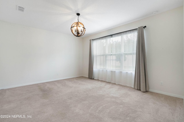 unfurnished room with light carpet and a chandelier