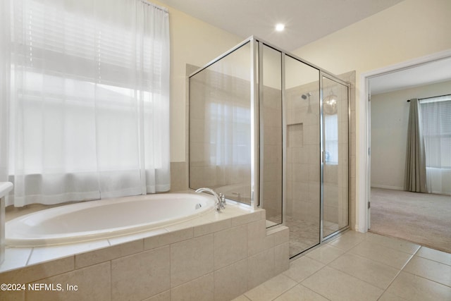 bathroom featuring shower with separate bathtub and tile floors