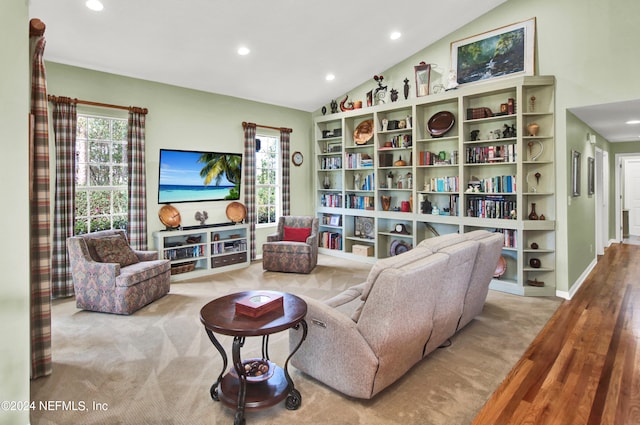 living room with light hardwood / wood-style floors and vaulted ceiling