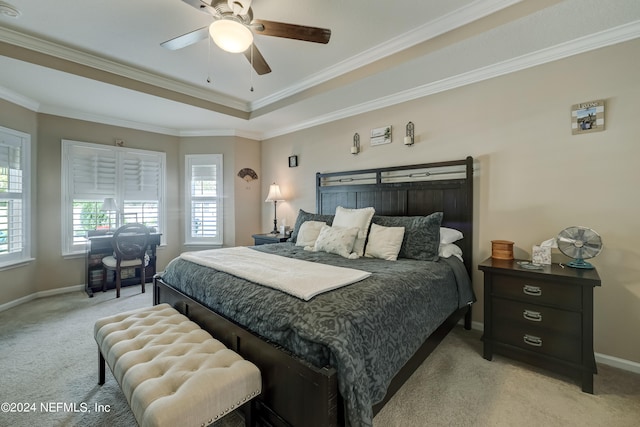 bedroom featuring a tray ceiling, light carpet, crown molding, and ceiling fan