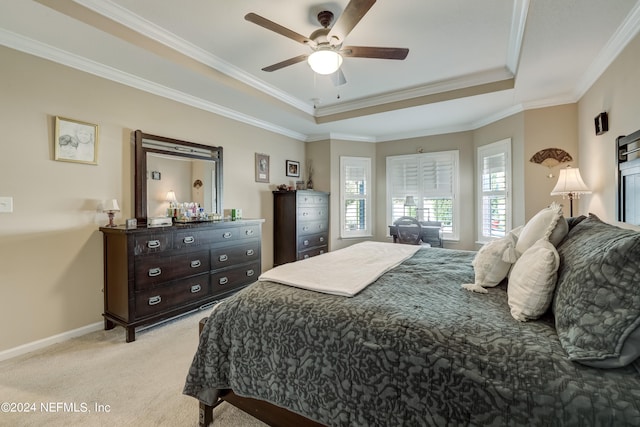 carpeted bedroom with ornamental molding, ceiling fan, and a tray ceiling