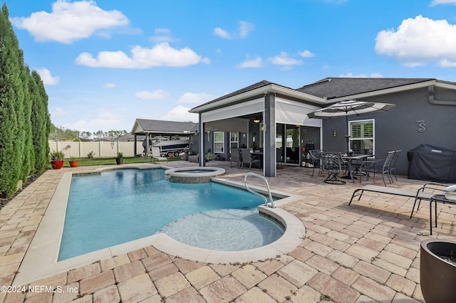 view of pool with grilling area, a patio area, and an in ground hot tub