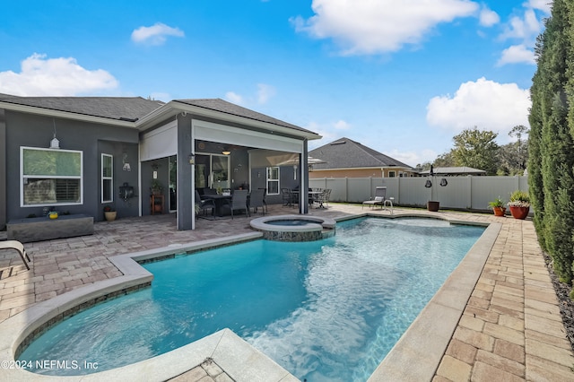 view of swimming pool featuring a patio area and an in ground hot tub