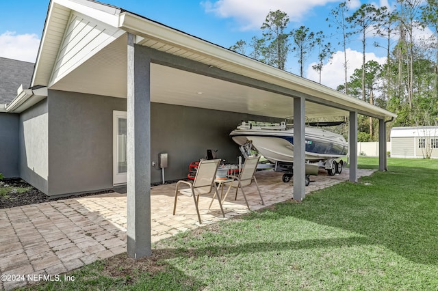 back of property with a carport, a yard, and a patio area