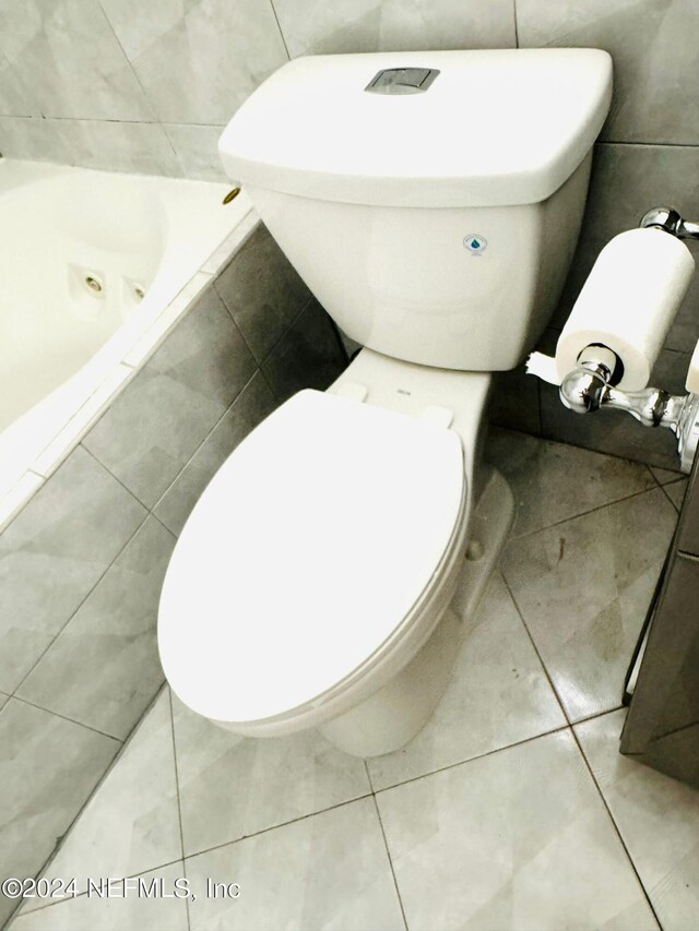 1530 El Prado Rd Unit 5, Jacksonville, FL 32216 - bathroom featuring tile walls, tiled tub, toilet, and tile flooring
