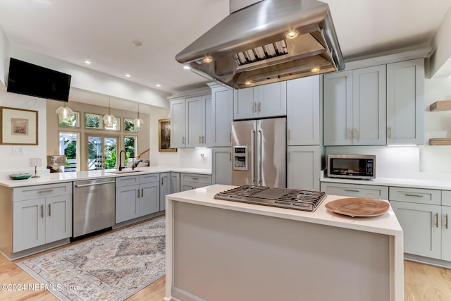 kitchen with appliances with stainless steel finishes, light hardwood / wood-style flooring, and island exhaust hood