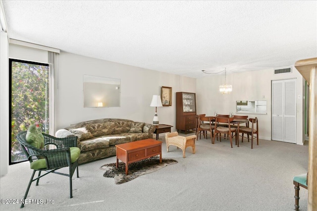 carpeted living room featuring a textured ceiling and an inviting chandelier