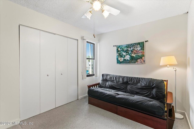 living room featuring a textured ceiling and ceiling fan