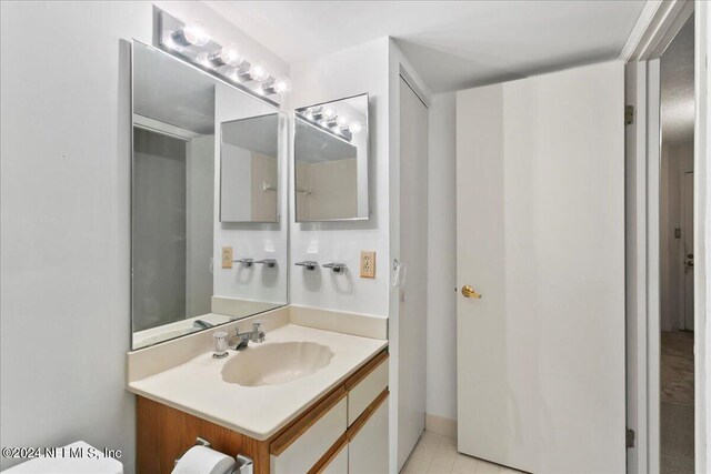 bathroom with vanity, tile patterned flooring, and toilet