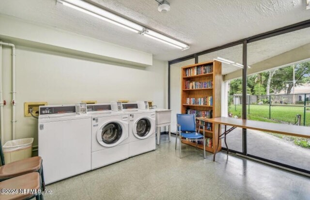 washroom with light tile patterned floors, a textured ceiling, and washing machine and clothes dryer