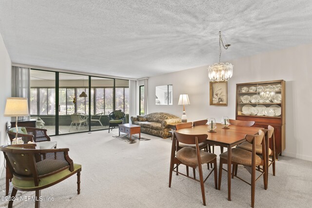 dining area with a notable chandelier, floor to ceiling windows, a textured ceiling, and light colored carpet